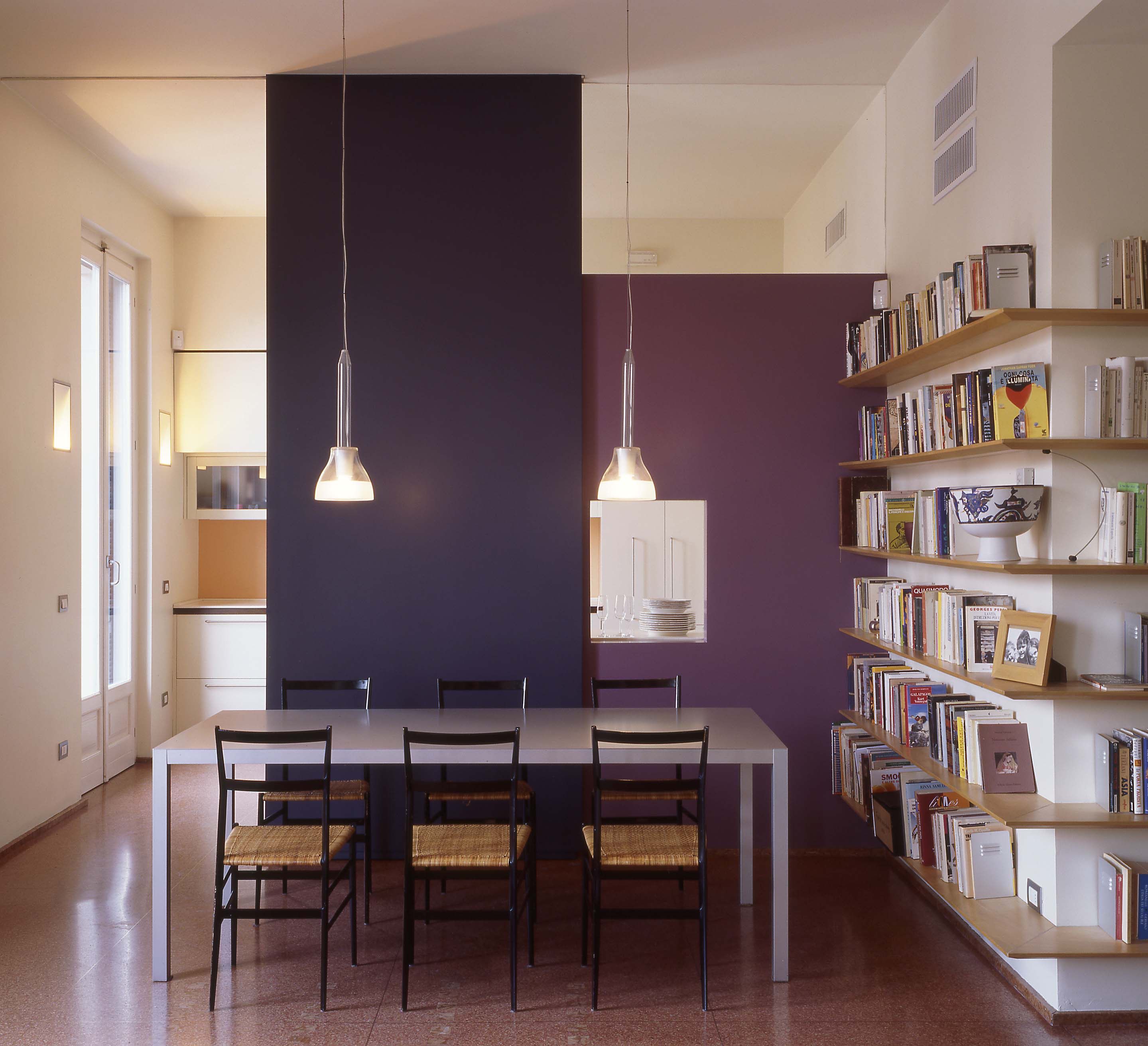 La sala da pranzo colorata illuminata dalla luce che arriva dal soffitto